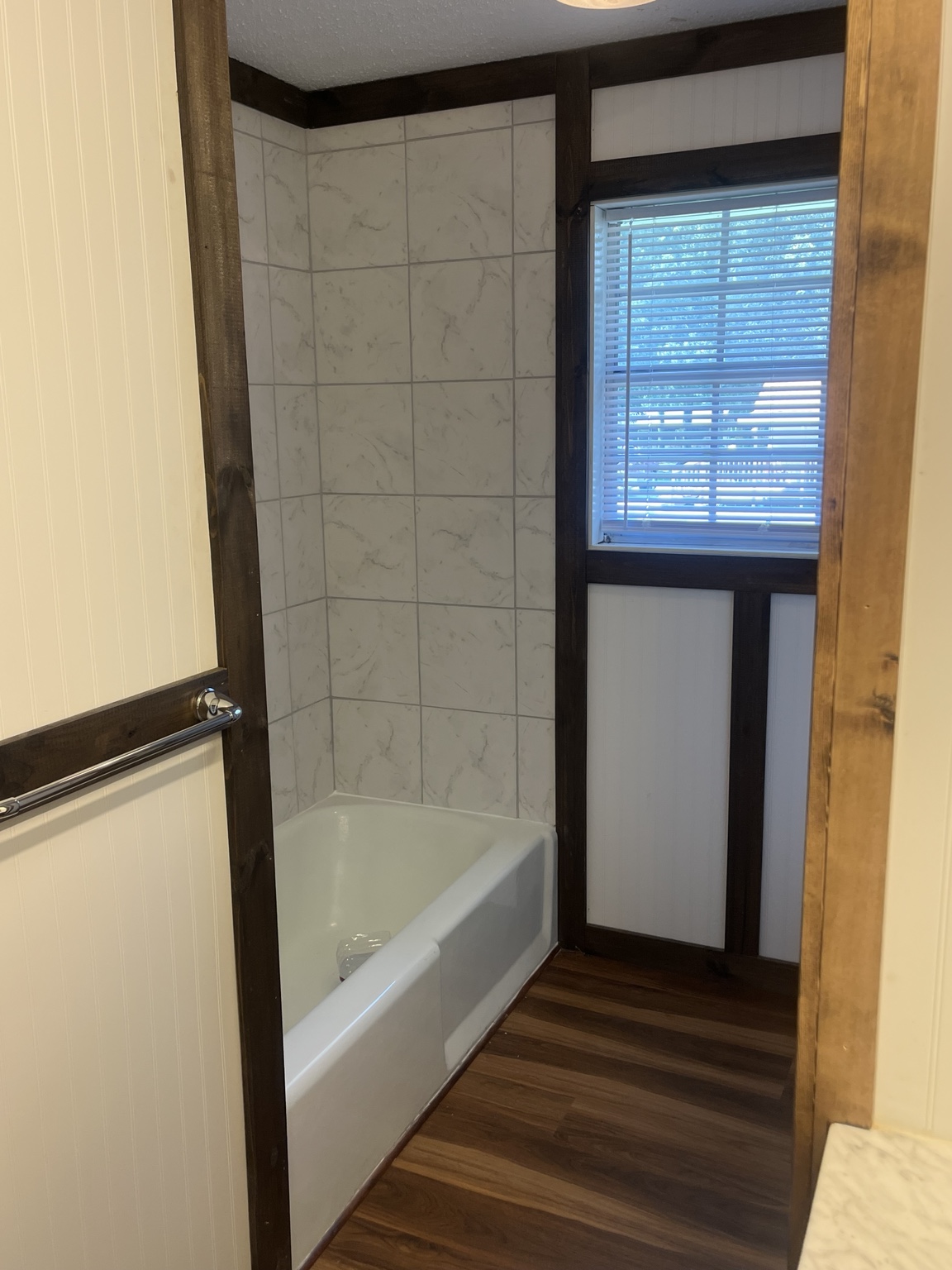 Bathroom tub with tiled surround and window