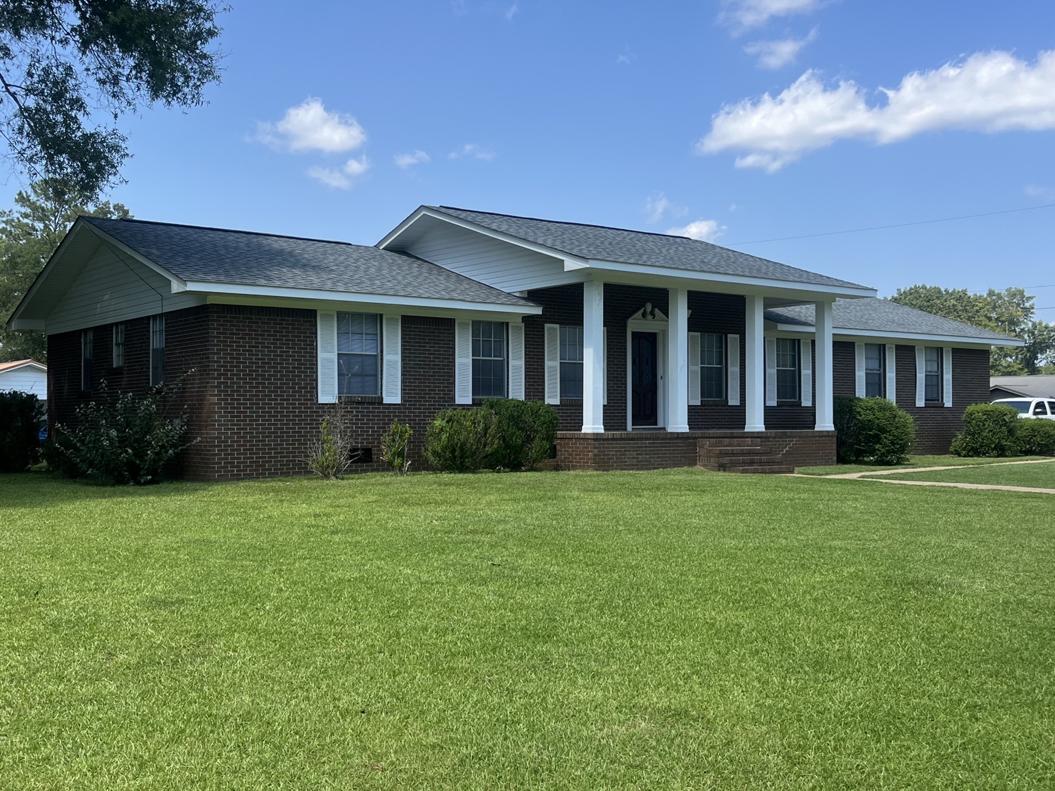 Angled exterior view of the brick home and front lawn