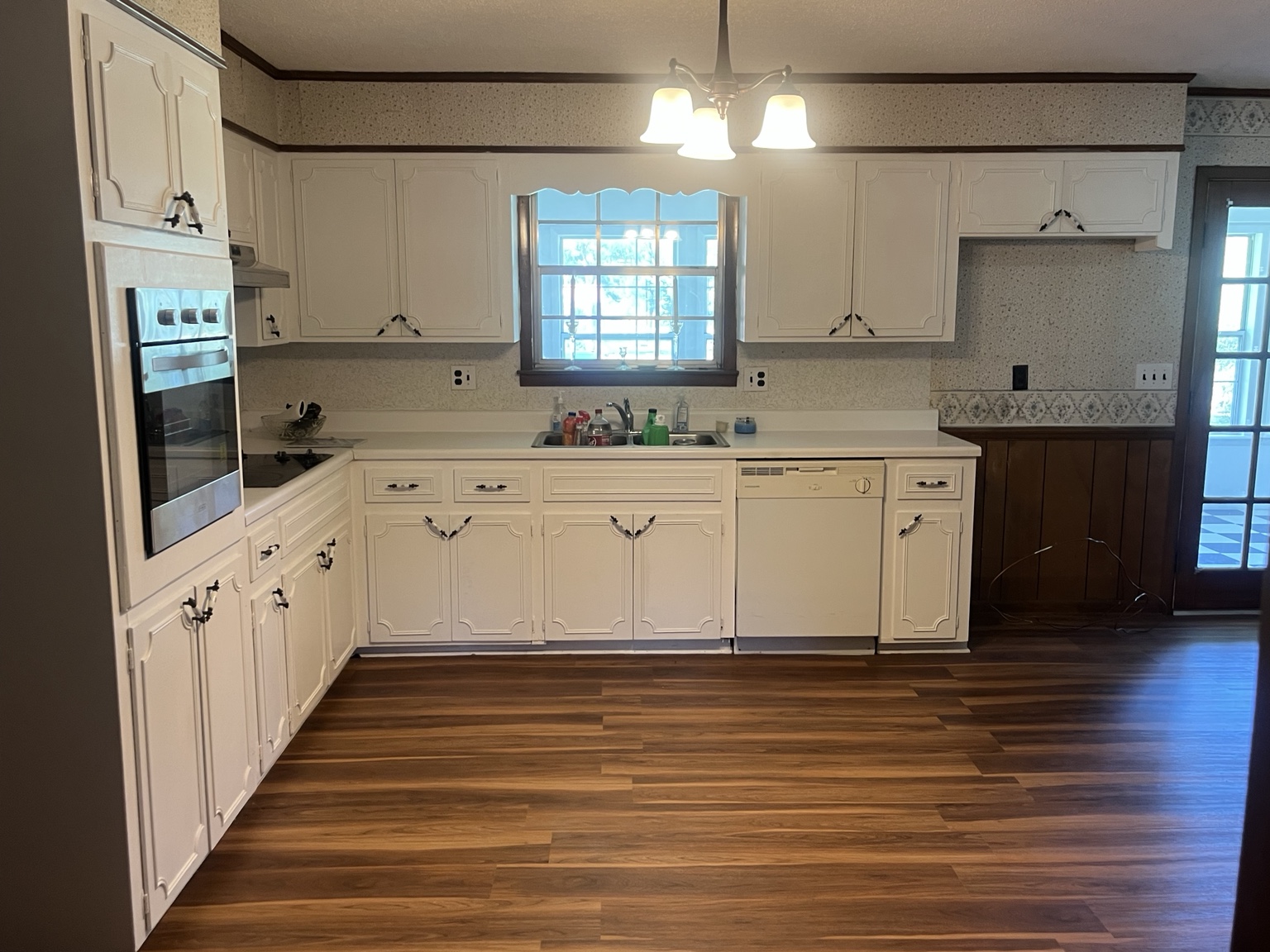Kitchen with white cabinetry and updated flooring